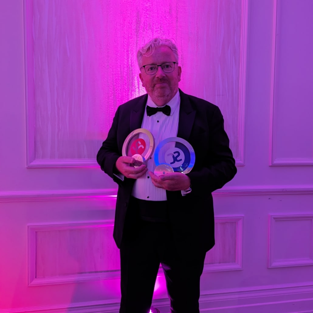 Paul Ayers, CEO of Noetic, holding the awards